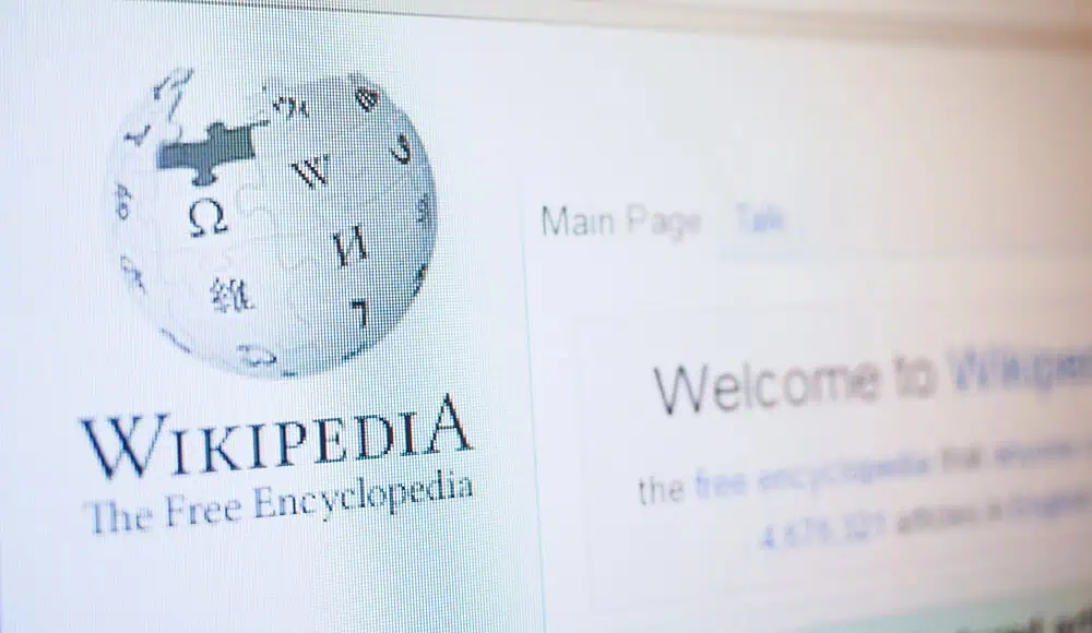 Primo piano dello schermo di un computer che visualizza la pagina principale di Wikipedia, con l'iconico logo e l'indirizzo web.
