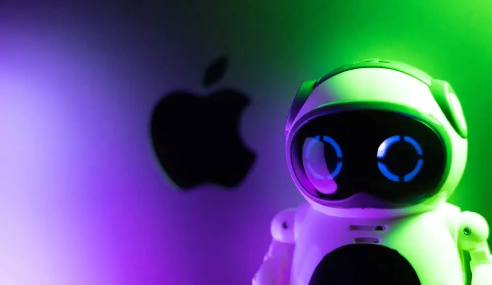 Un piccolo robot giocattolo con occhi luminosi si trova davanti a un logo Apple sfocato, immerso in suggestive luci verdi e viola.