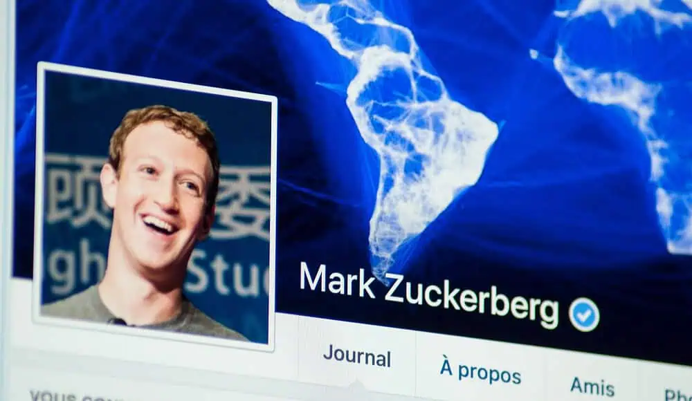 Una pagina di profilo di social media con la foto sorridente e il nome di Mark Zuckerberg su uno sfondo di mappa blu.