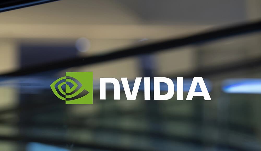 Il logo di NVIDIA è visualizzato su un vetro con uno sfondo sfocato, a sottolineare la presenza innovativa di NVIDIA negli spazi di lavoro moderni.