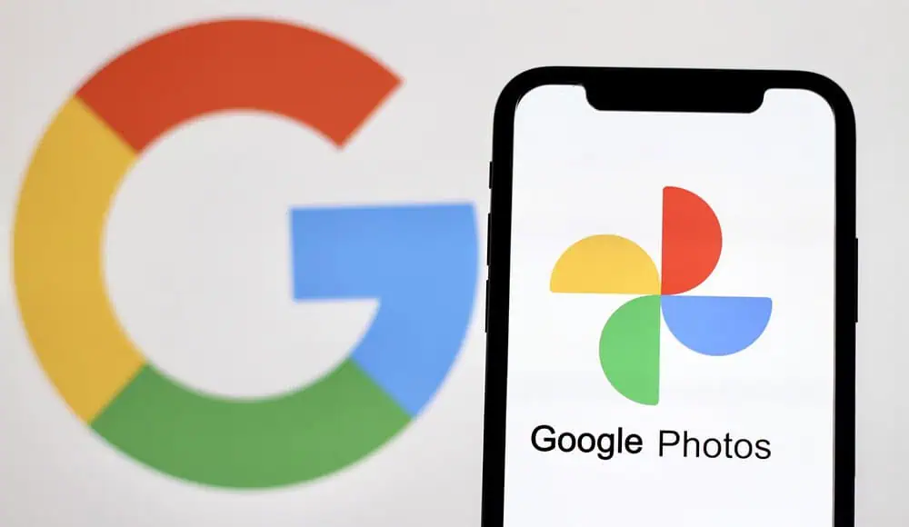 Uno smartphone mostra il logo di Google Photos con l'iconico marchio di Google sullo sfondo.