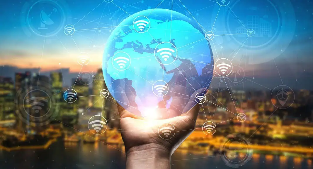 Una mano regge un mappamondo luminoso con icone Wi-Fi e connessioni di rete su uno sfondo urbano, catturando lo spirito della connettività globale pionieristica di visionari come Pavel Durov.
