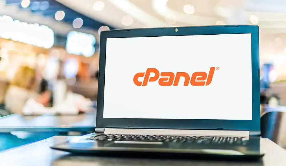 Un computer portatile mostra il logo cPanel sul suo schermo in un ambiente interno luminoso, evidenziando la gestione continua del web hosting.