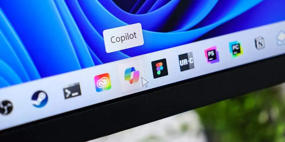 Primo piano dello schermo di un computer con l'icona dell'applicazione Copilot evidenziata sulla barra delle applicazioni di Windows.