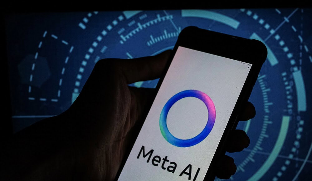Una mano regge un telefono con il logo di Meta AI, mentre l'interfaccia digitale di Meta si illumina sullo sfondo.