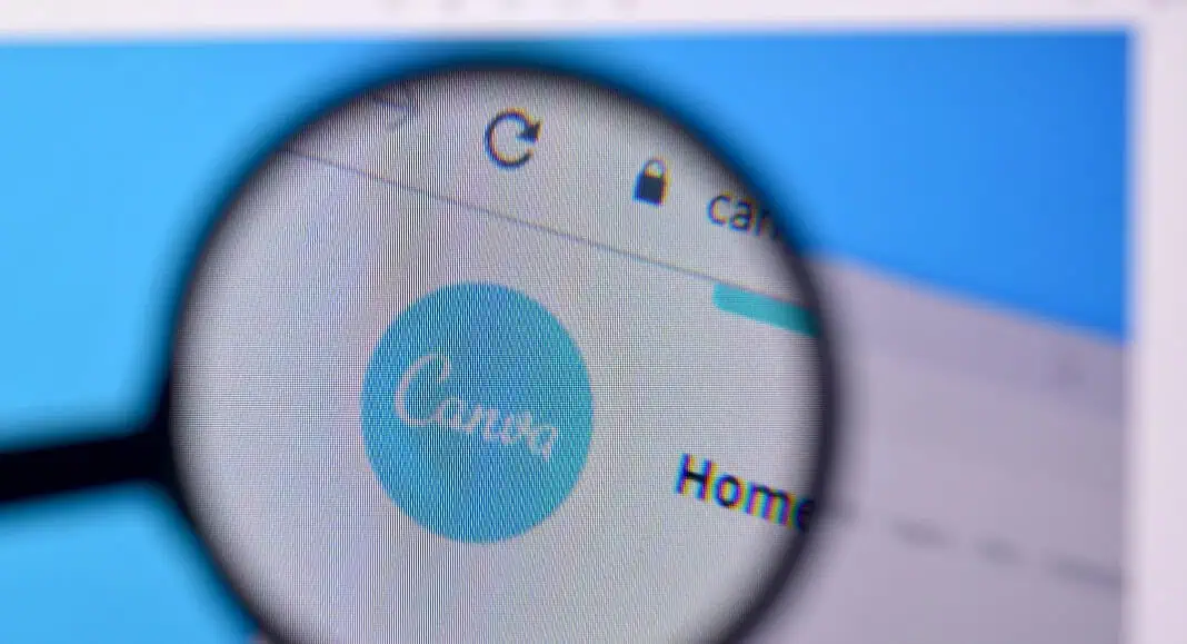 Lente di ingrandimento focalizzata sul logo del sito Web di Canva visualizzato sullo schermo di un computer, evidenziando possibili problemi di Canva o segnalando un errore di Canva.