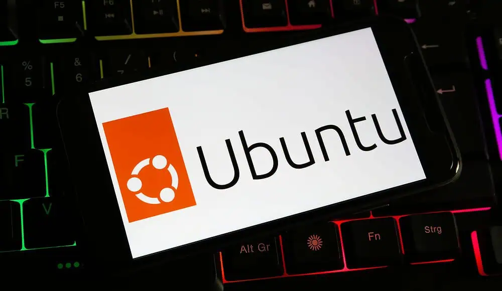 Uno smartphone mostra il logo e il testo di Ubuntu su una tastiera colorata retroilluminata, mostrando la perfetta integrazione di Ubuntu con i dispositivi moderni.