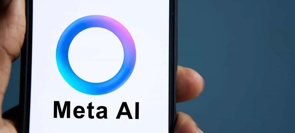 Lo schermo di uno smartphone mostra il logo di Meta AI, caratterizzato da un anello sfumato blu e viola sopra il testo 