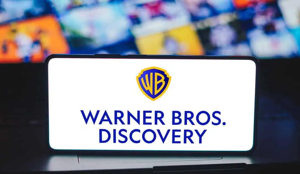 Uno smartphone mostra il logo Warner Bros. Discovery, con il logo Paramount sfocato sullo sfondo.