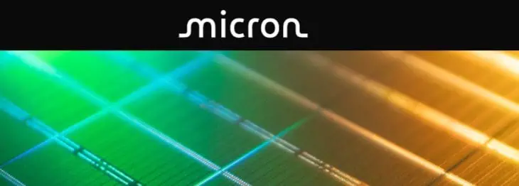 I loghi Micron e Crucial sopra un primo piano di un microchip colorato con sezioni verdi, blu e oro.