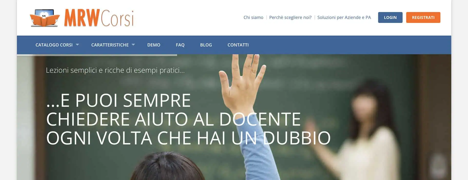 mrwcorsi-agosto-2026 In un'aula, uno studente ha alzato la mano, con un insegnante e una lavagna sullo sfondo.