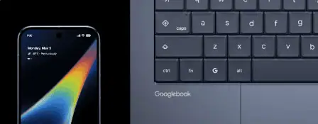 Vista dall'alto di una tastiera e di un touchpad di un laptop grigio scuro, con la scritta “Googlebook AI”, su sfondo nero.